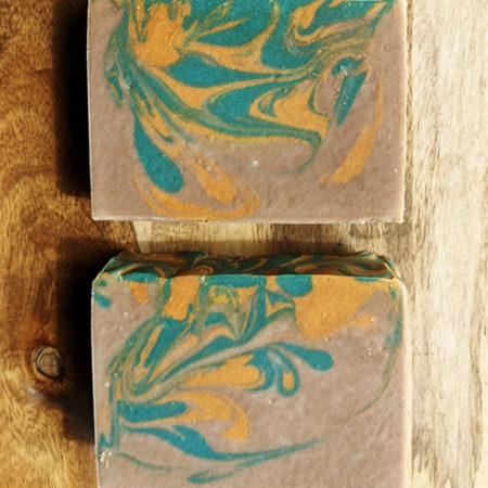 Medium brown bars of soap with green and gold swirling throughout.