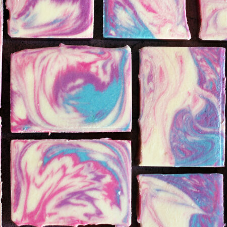 Swirled white, pink, purple and blue bars of soap.