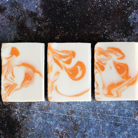 Three bars of soap, swirled with white and orange.