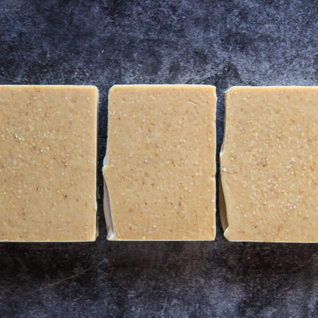 Three bars of creamy looking natural tan soap, flat laid so you can see the texture from the oats.